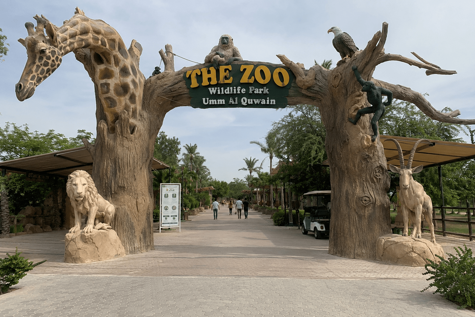 Entrance to The Zoo Wildlife Park Umm Al Quwain featuring realistic animal sculptures, lush greenery, and a welcoming pathway for visitors in the UAE.